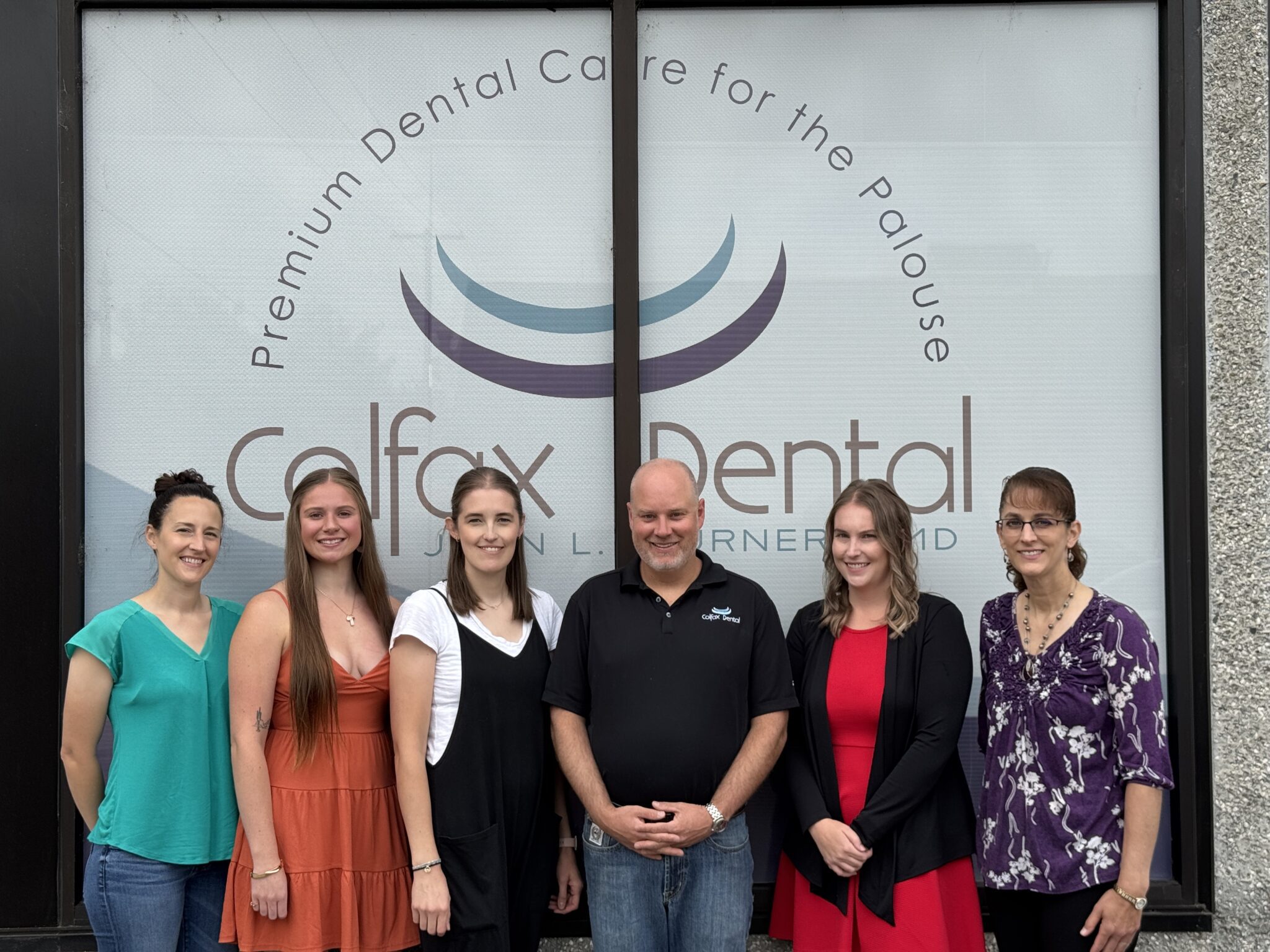 John Turner DMD standing with staff members smiling at Colfax Dental
